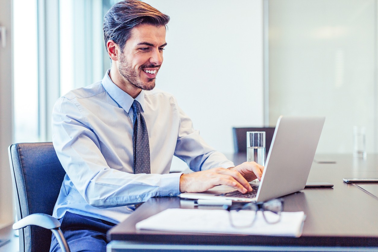 Smiling businessman warking in his office, with copy space.